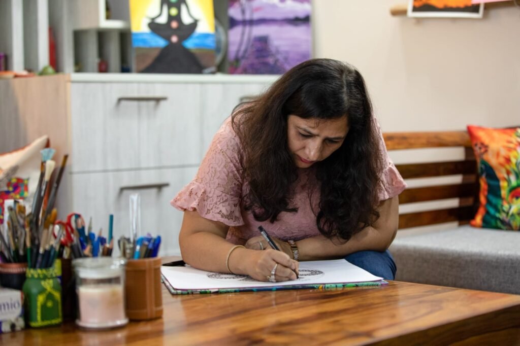 Vandana Bhasin drawing a mandala at her table