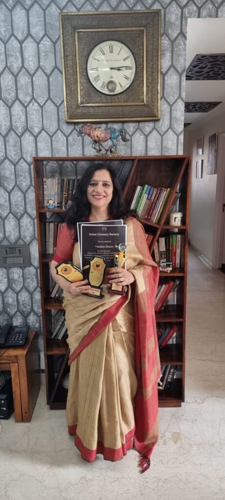 Vandana Bhasin holding literary award plaques and an Asian Literary Society certificate